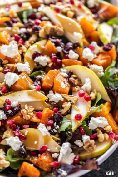 butternut squash salad with pears, goat cheese, pomegranate arranged on a plate