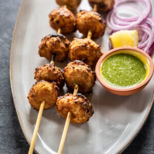 tandoori mushrooms arranged on skewer served with cilantro chutney