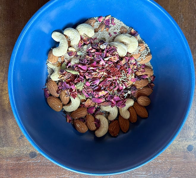 cashews, almonds, rose petals, fennel, peppercorn in a blue color bowl