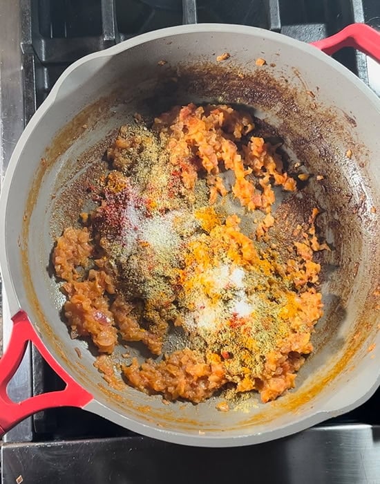 pureed onion tomato with spices and salt in a pan
