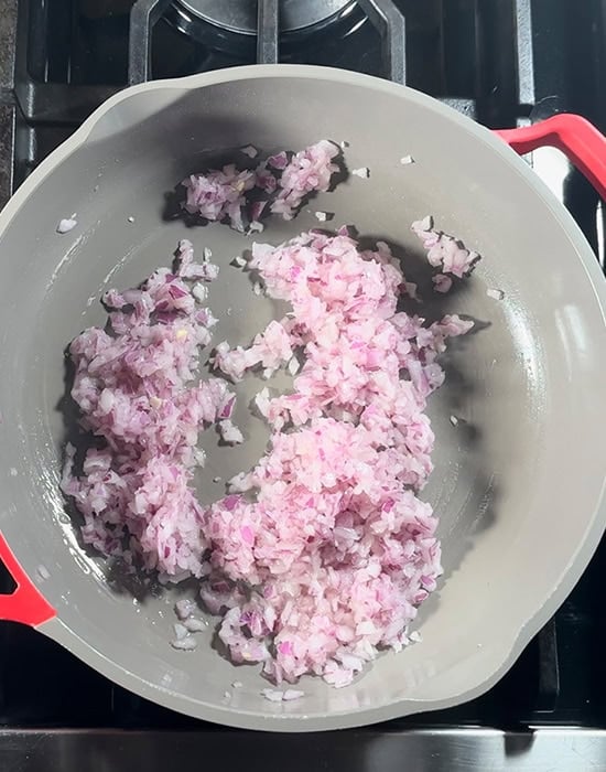 finely chopped onion being cooked in a nonstick pan