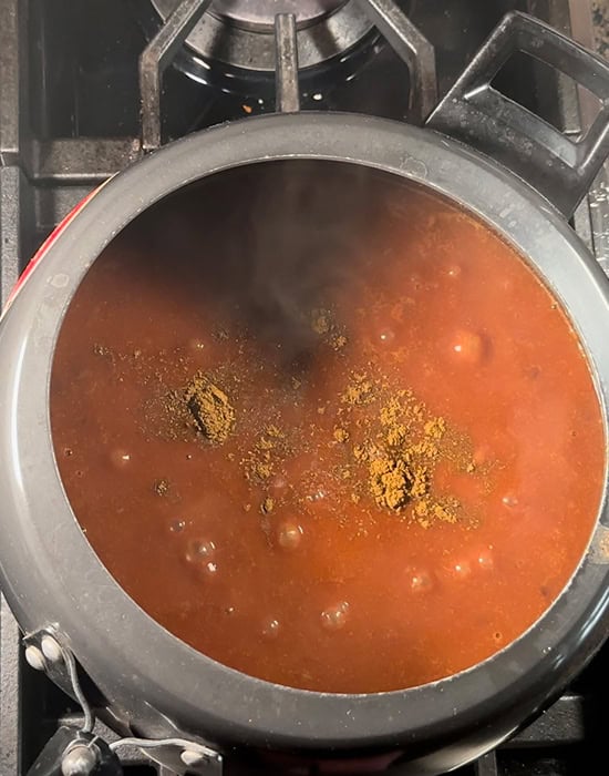 garam masala being sprinkled on top of rajma