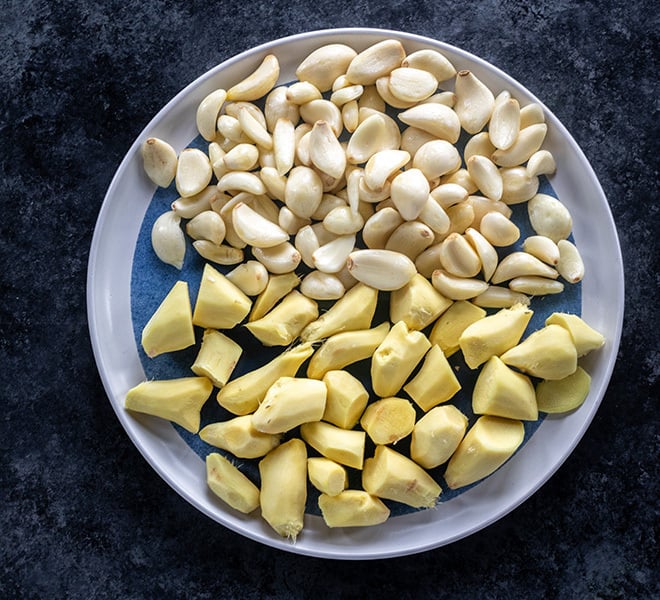 peeled ginger and peeled garlic in a plate