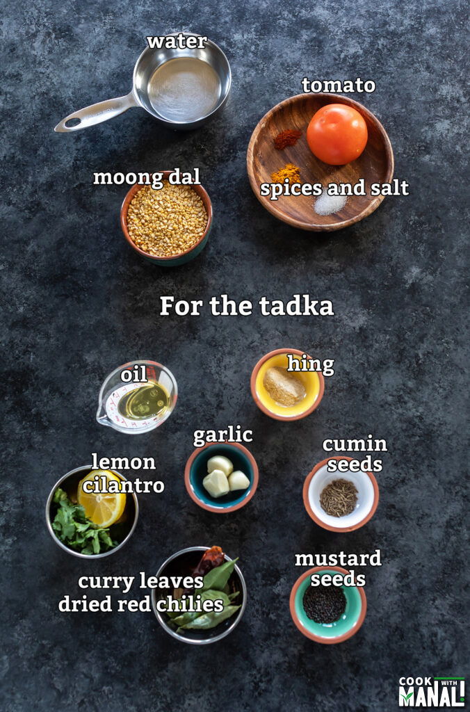 ingredients to make moong dal arranged on a board
