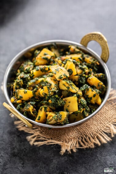 aloo palak served in a copper kadai