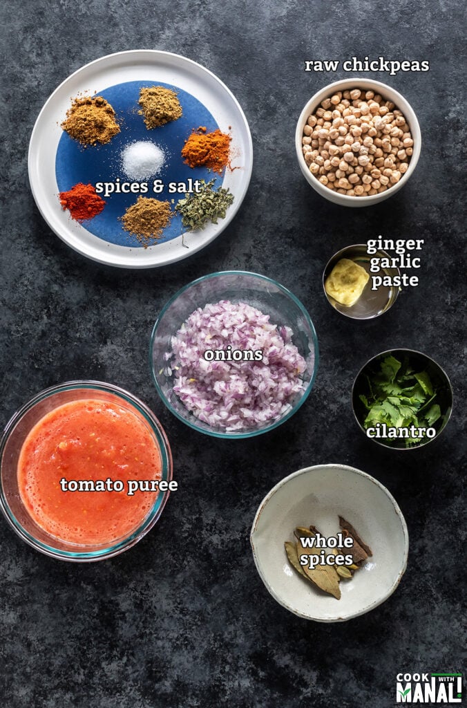 ingredients for making chole masala arranged on a board