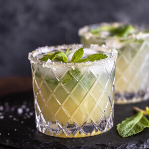 cucumber mocktail served in a glass which has salt flakes on the rim and garnished with mint leaves