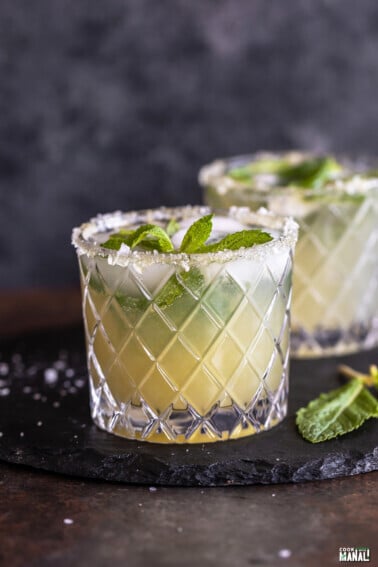 cucumber mocktail served in a glass which has salt flakes on the rim and garnished with mint leaves