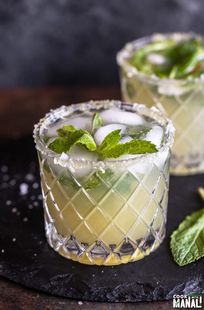 cucumber mocktail served in a glass which has salt flakes on the rim and garnished with mint leaves