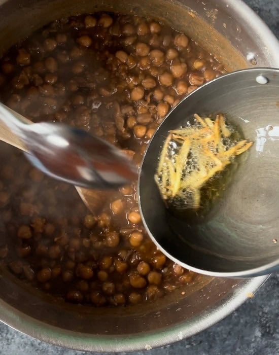 pouring tadka of ginger into the chole