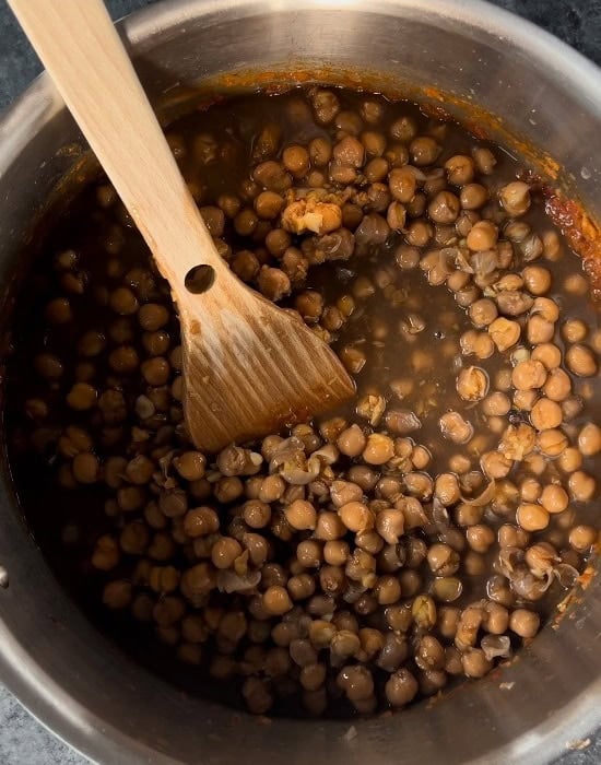 boiled chickpeas added to the masala in a pot