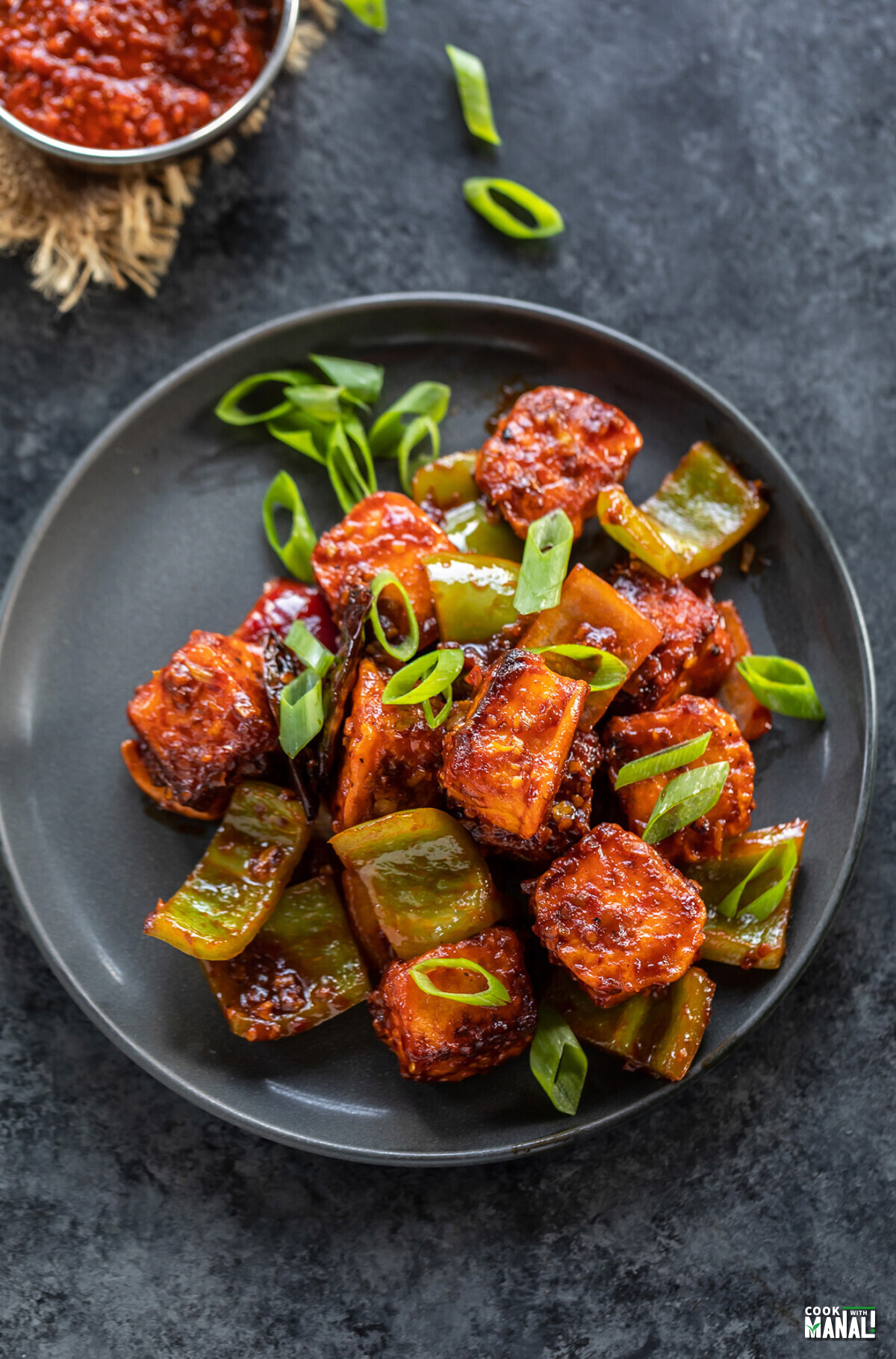 paneer cubes tossed in sauce garnished with green onions