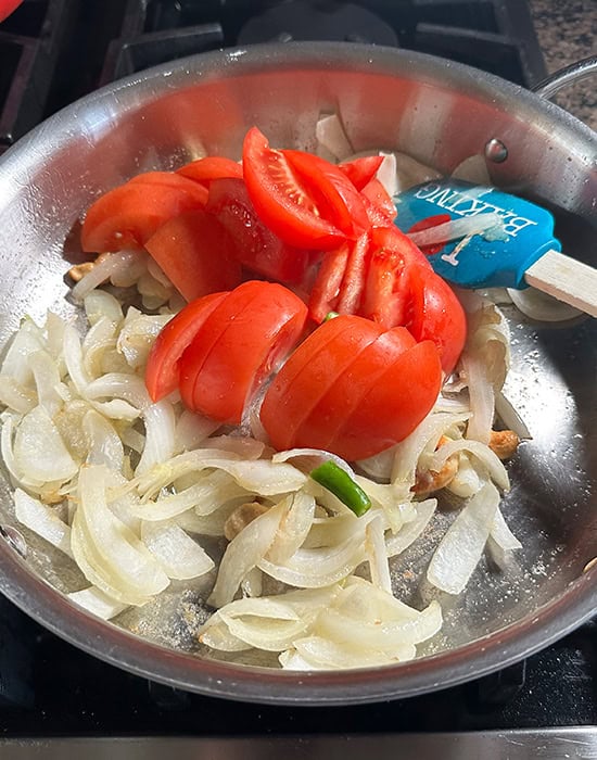 sliced onions and tomatoes in a steel pan