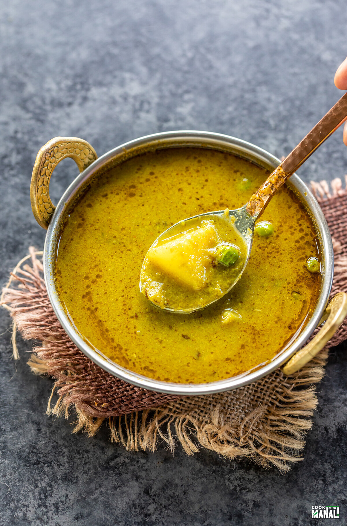 nimona curry served in a copper kadai with a copper spoon