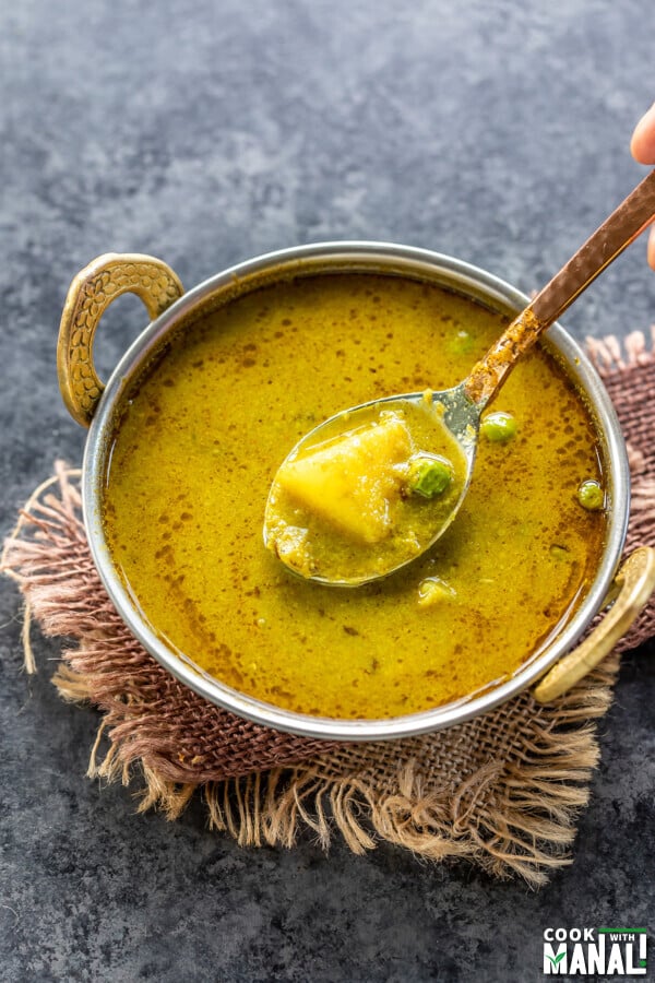 nimona curry served in a copper kadai with a copper spoon