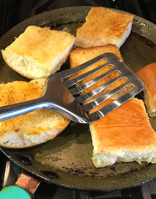 spatula pressing and toasting the buns