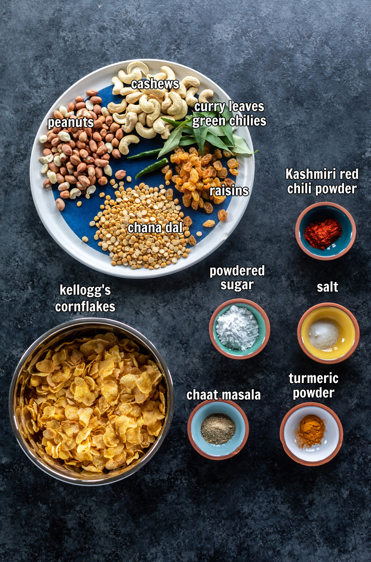 ingredients for making corn flakes chivda arranged on a board