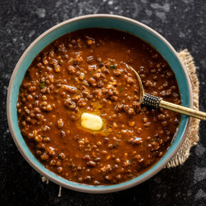 urad dal served with butter in a blue color bowl