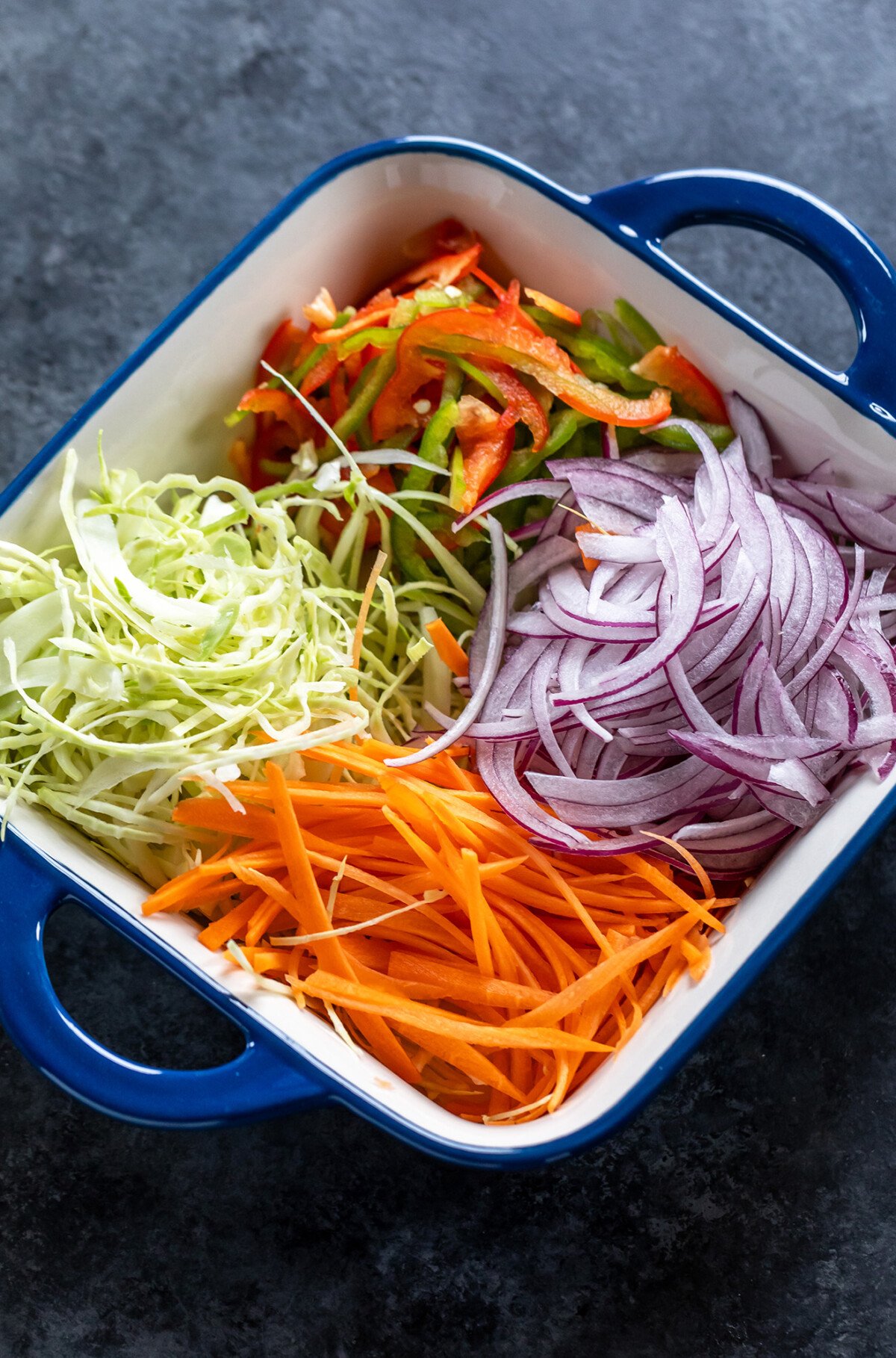 thinly sliced vegetables arranged in a pan