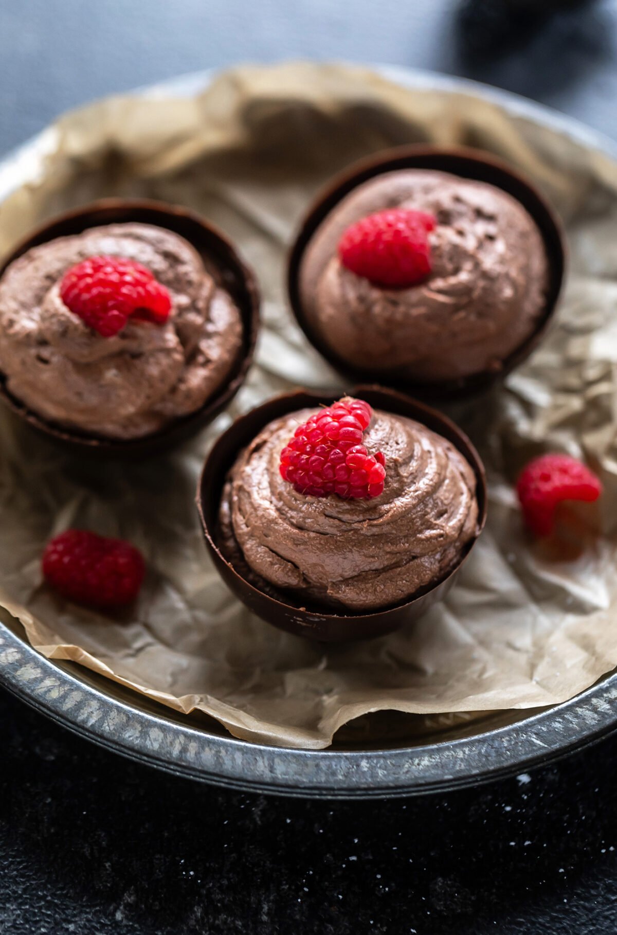 chocolate mousse served in chocolate bowls topped with raspberry