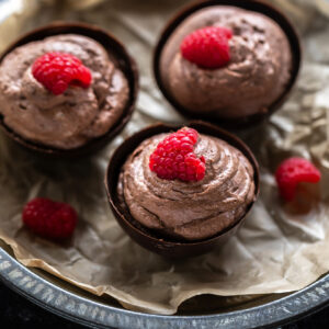 chocolate mousse served in chocolate bowls topped with raspberry