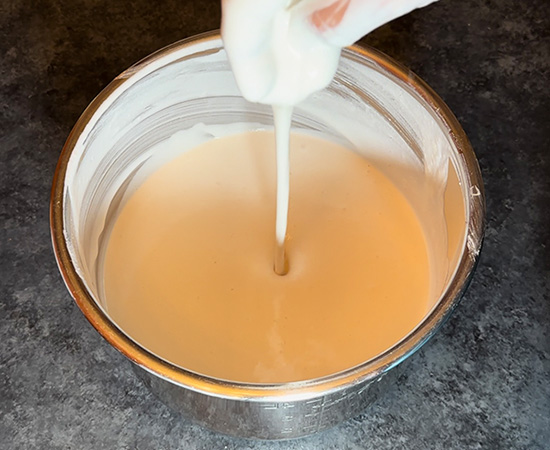 flowing idli batter showing the consistency of the batter