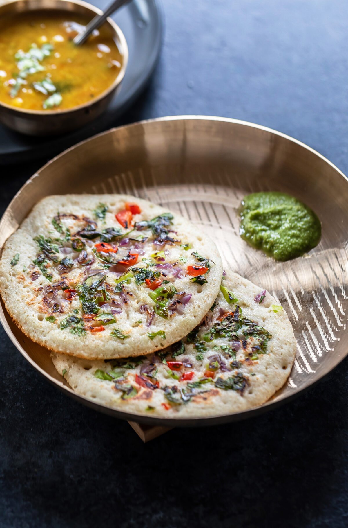 2 rava uttapam served with coconut chutney and bowl of sambar