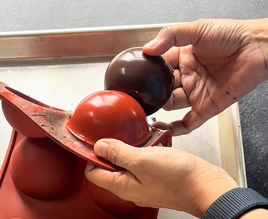 chocolate cup being removed from silicone mold