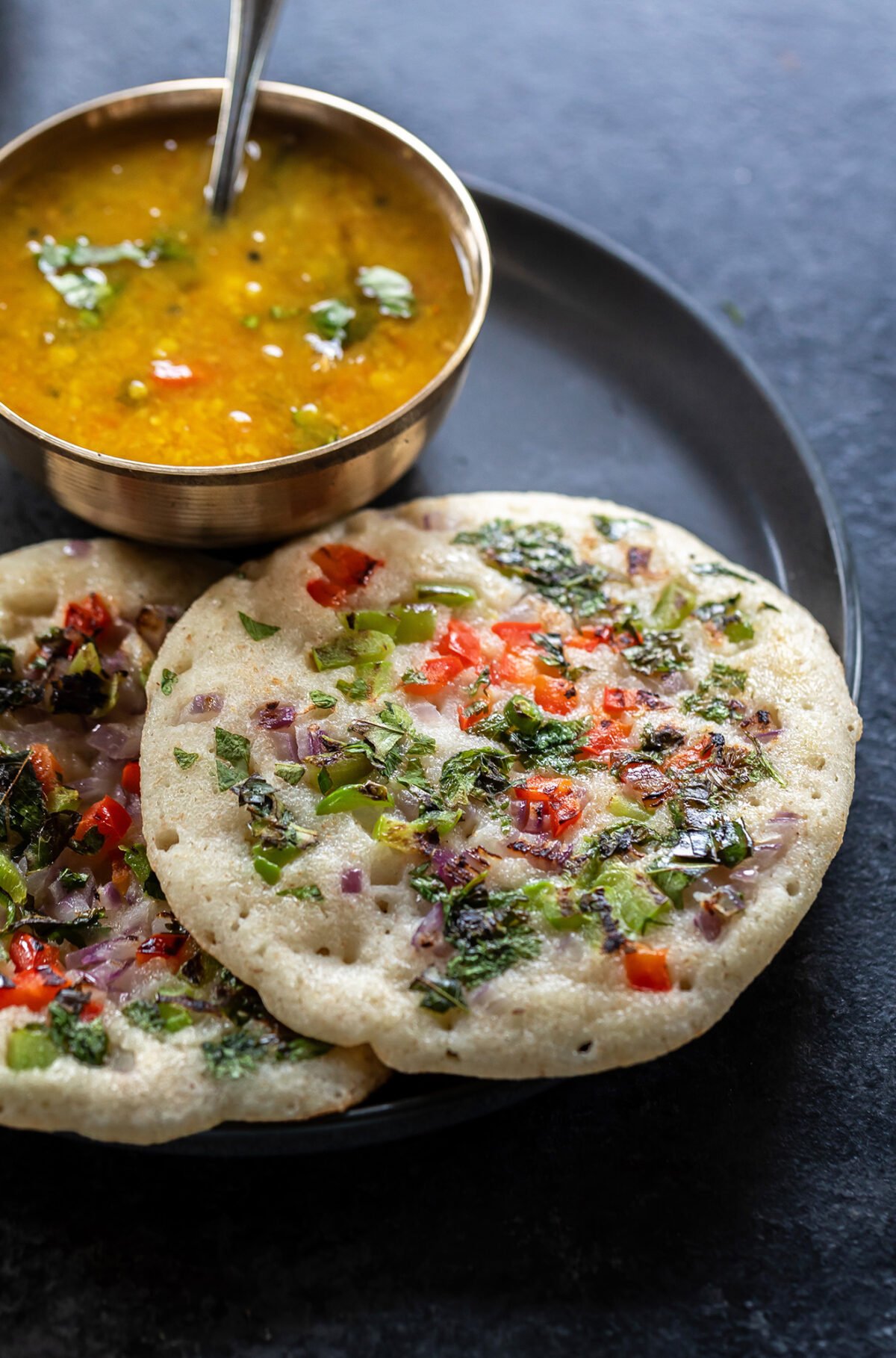 suji uttapam with sambar  served in a kansa plate