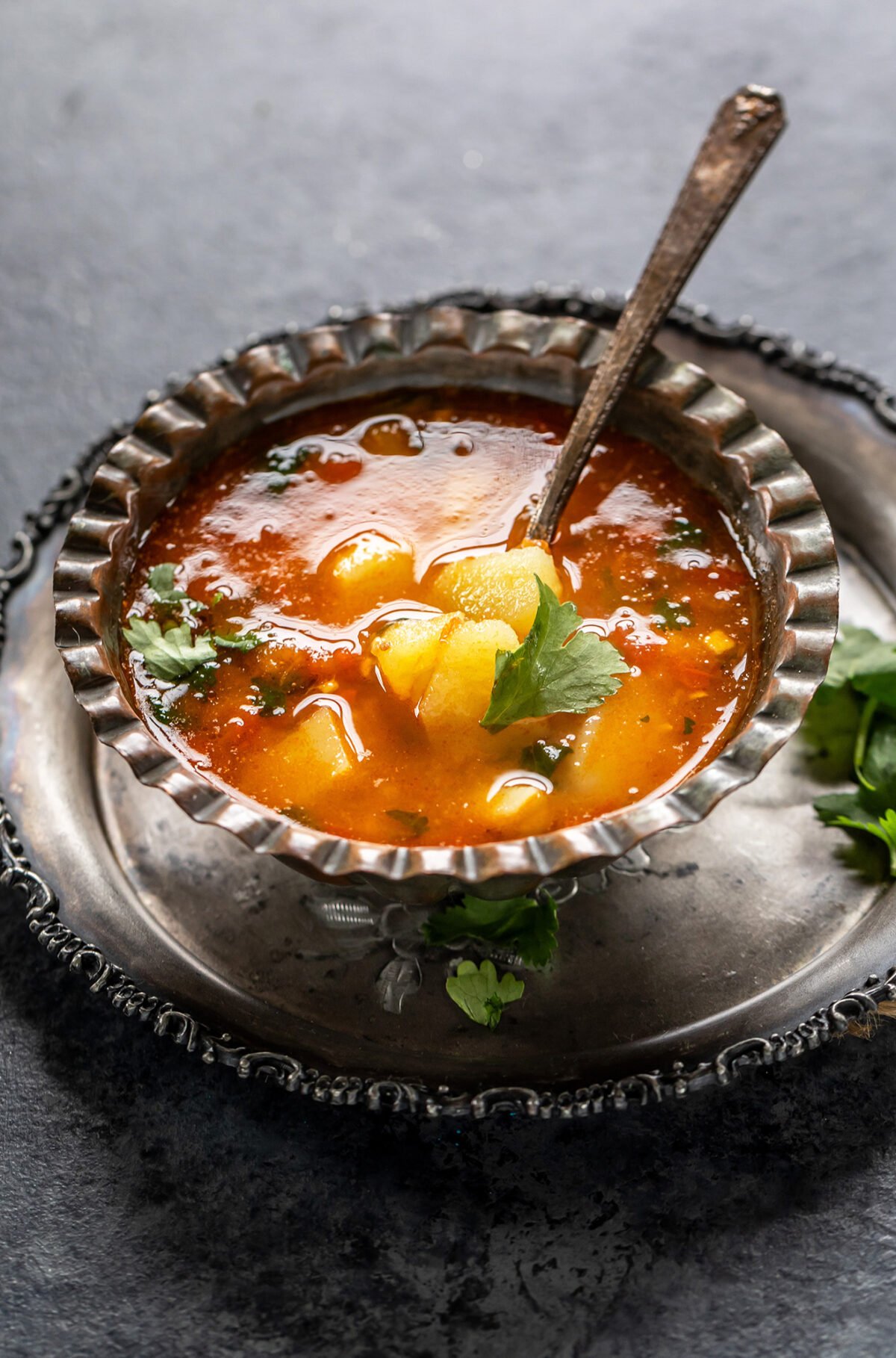 vrat wale aloo served in an antique bowl with a spoon on the side