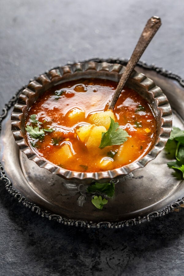 vrat wale aloo served in an antique bowl with a spoon on the side