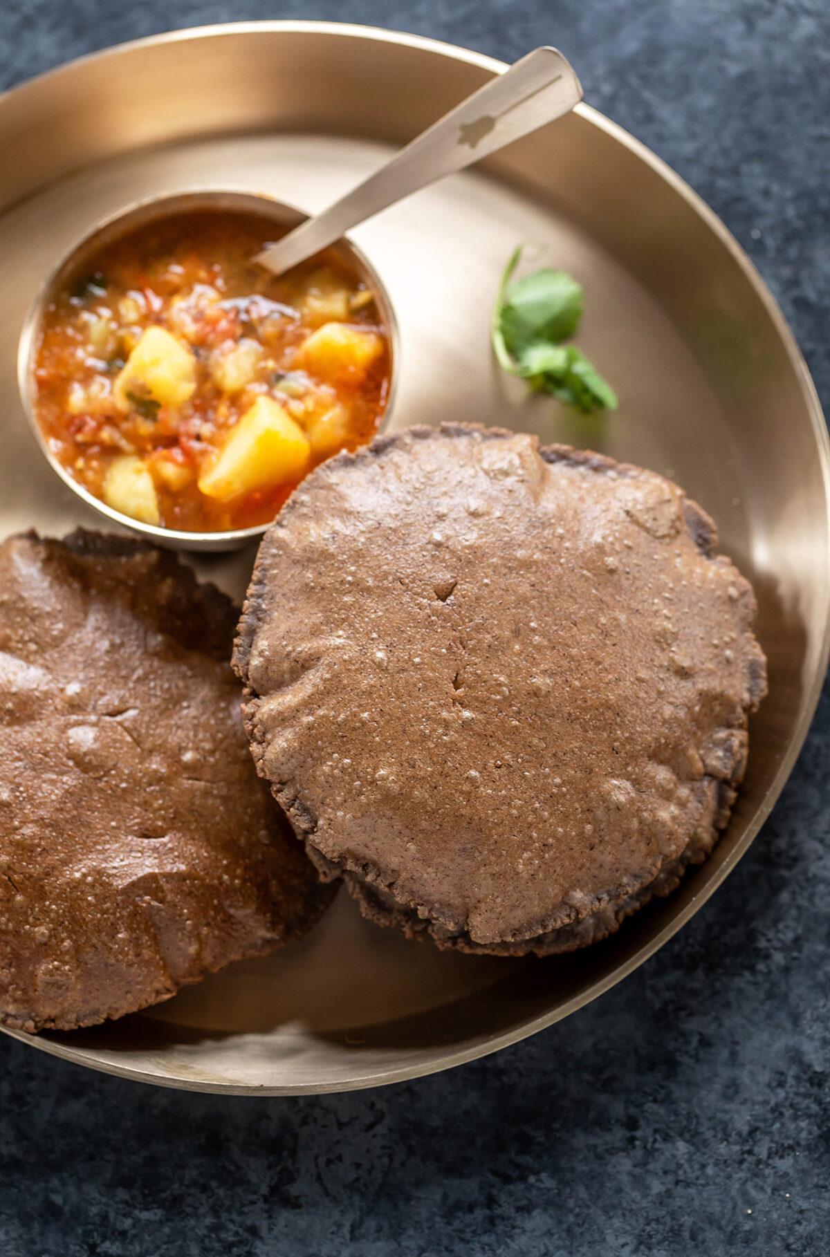 round puris served in a plate with aloo curry on the side