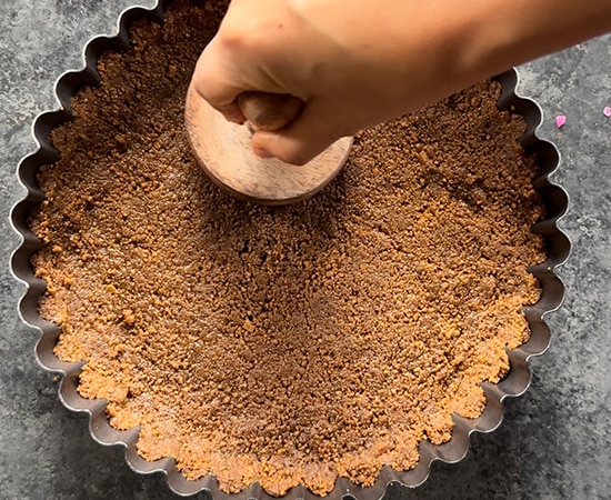 crust being pressed into a tart pan