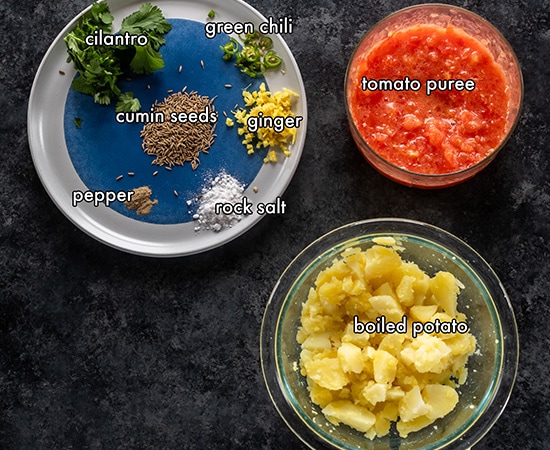 ingredients for aloo sabzi arranged on a board