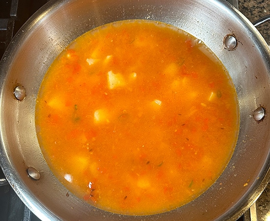 water added to potato curry in a kadai