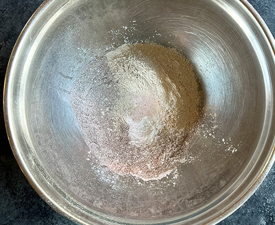 dry ingredients for ragi banana muffins in a steel bowl