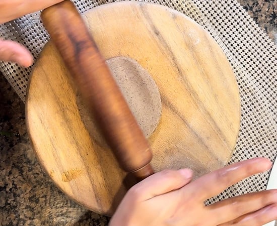 rolling kuttu puri with a rolling pin