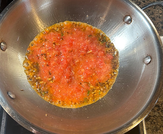 pureed tomatoes with spices in a kadai