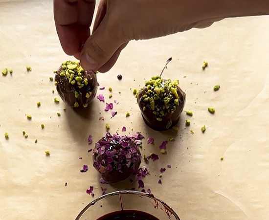 truffles being garnished with nuts and rose petals