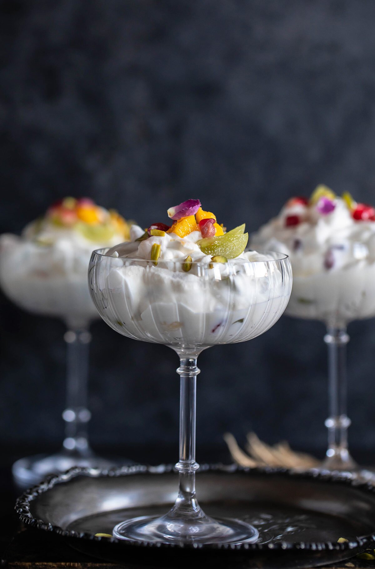 3 glasses filled with whipped cream and fruits