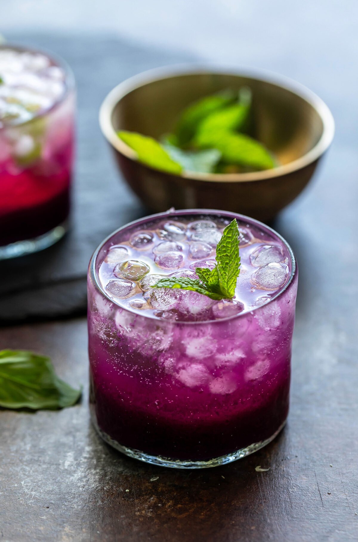 jamun mocktail in a glass garnished with mint with another glass placed in the background