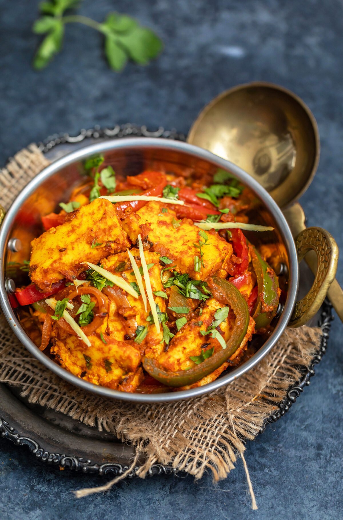 paneer dish garnished with ginger juliennes served in copper kadai