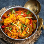 paneer dish garnished with ginger juliennes served in copper kadai