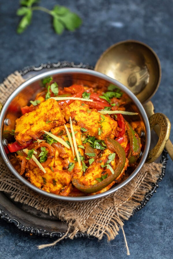 paneer dish garnished with ginger juliennes served in copper kadai