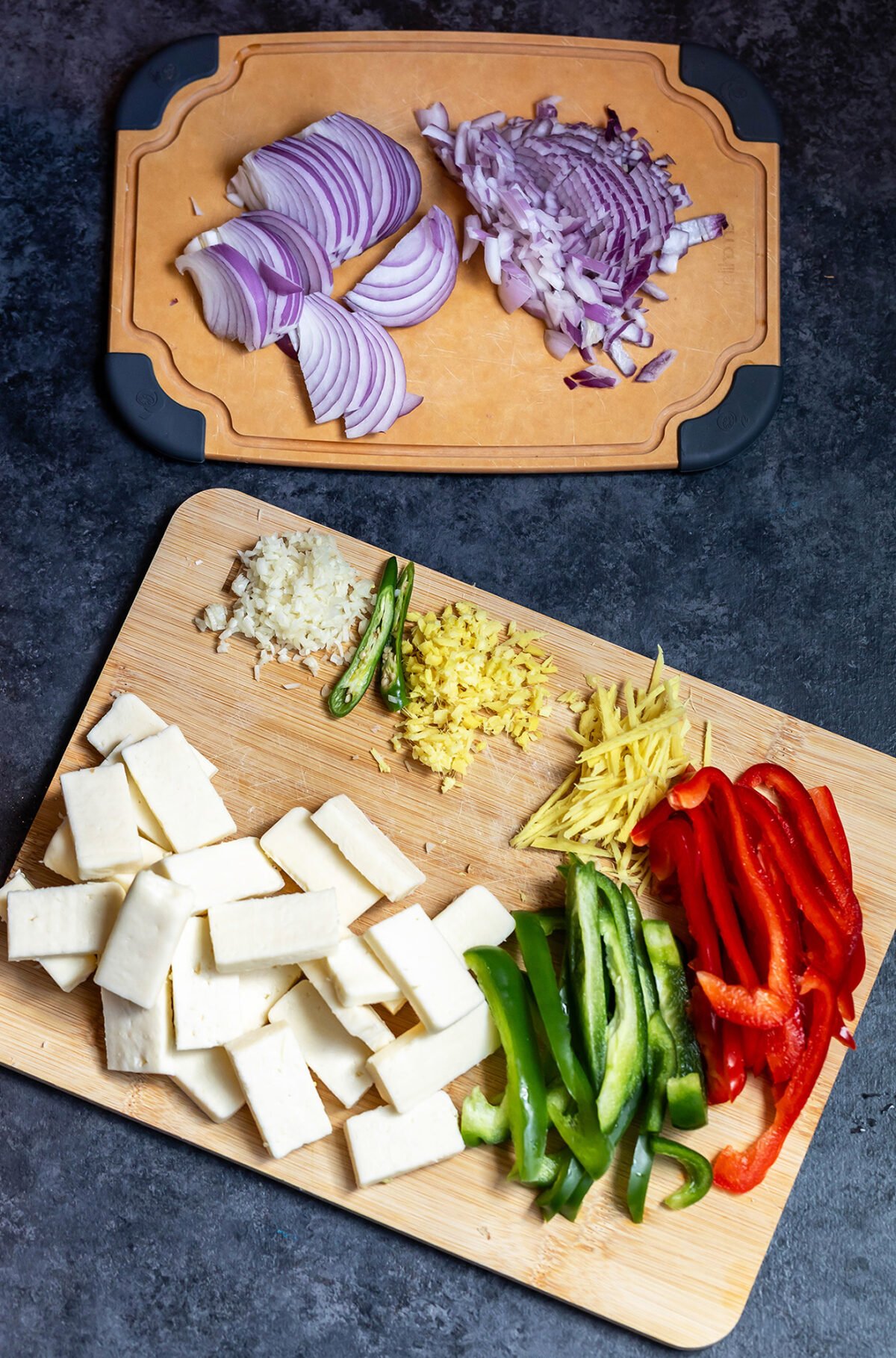 sliced onions, peppers and paneer arranged on chopping board