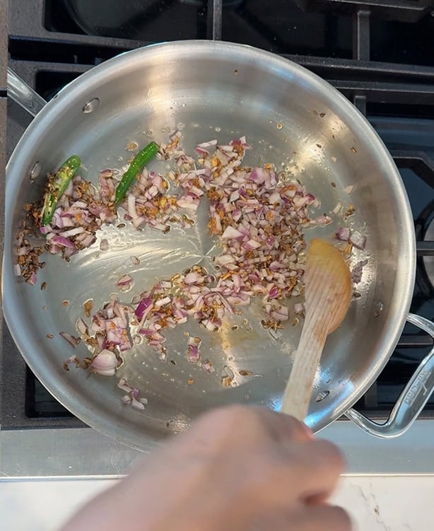 chopped onions with ginger, garlic and green chilies in a pan