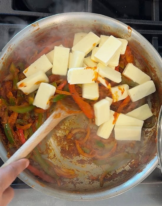 paneer cubes being added to gravy