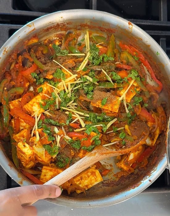 paneer cubes with ginger juliennes, peppers in a pan