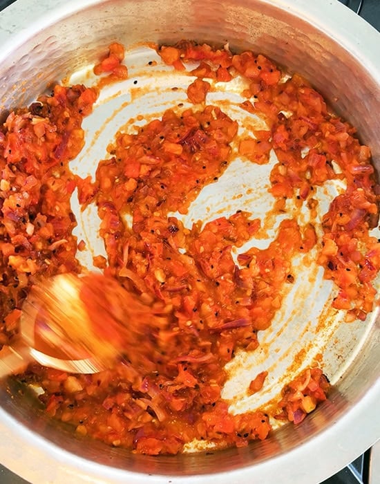 overhead shot of tomato masala being cooked in a pan