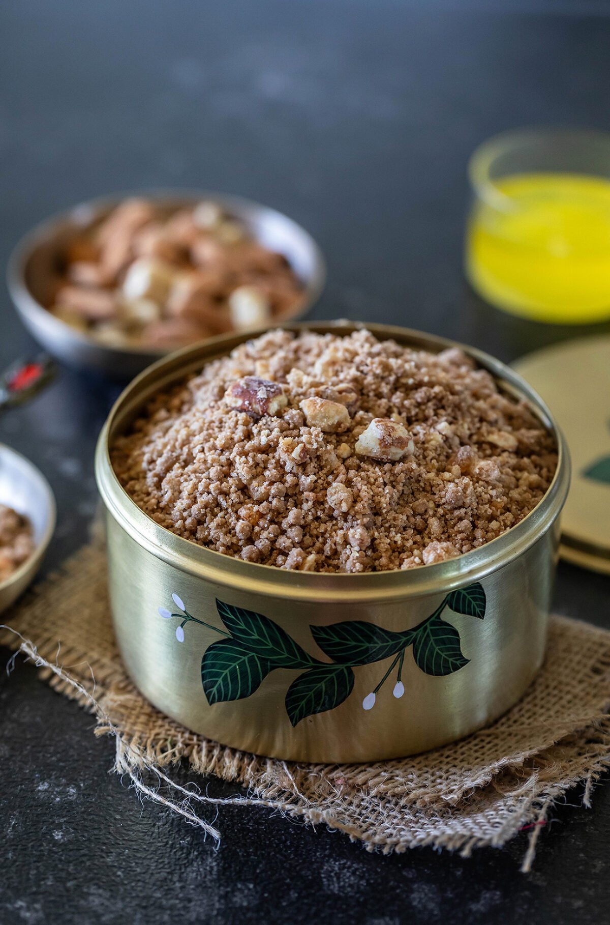 panjiri in a brass box garnished with nuts and a bowl of ghee placed in the background